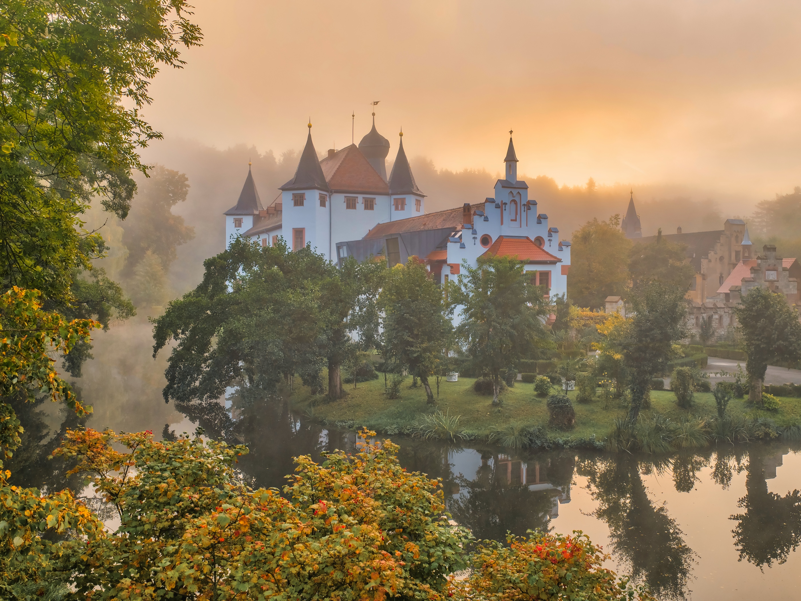Schloss Wolfersdorf im Herbst, Nebel-Sonnenaufgang über dem Teich