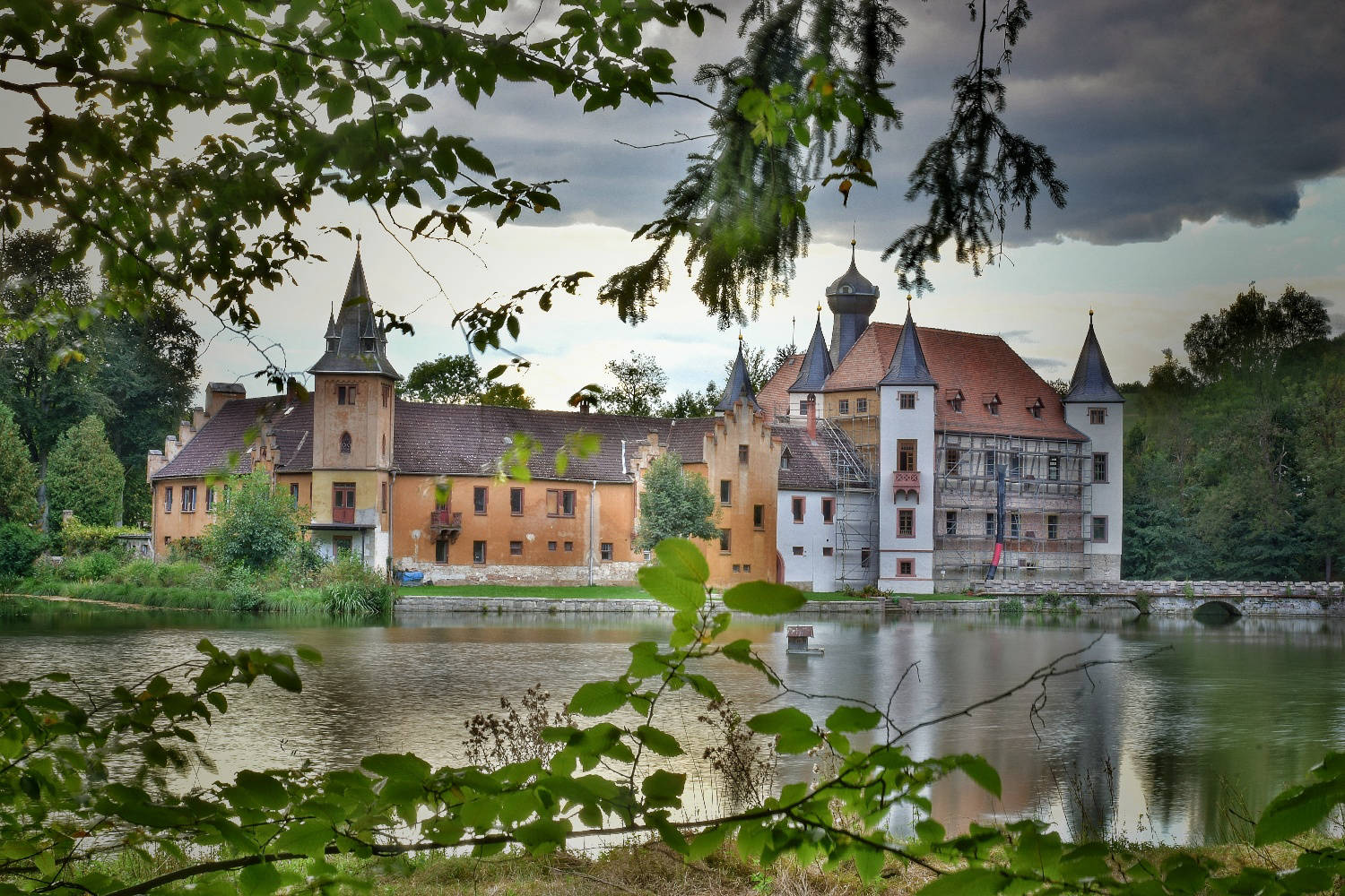 Schloss Wolfersdorf spiegelt sich im künstlich angestauten Teich